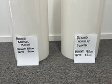Load image into Gallery viewer, Two round acrylic plinths with height and depth measurements on labels.
