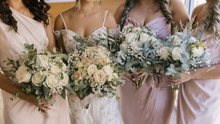 Load image into Gallery viewer, Bridesmaids holding bouquets with a bride in the center.
