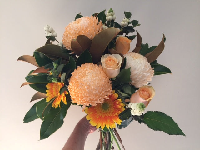 Bright hand tied bouquet with disbuds,roses in the medium size,gerberas,filler flowers and foliages of in season ingredients,gift wrapped and delivered with a water bag for freshness.