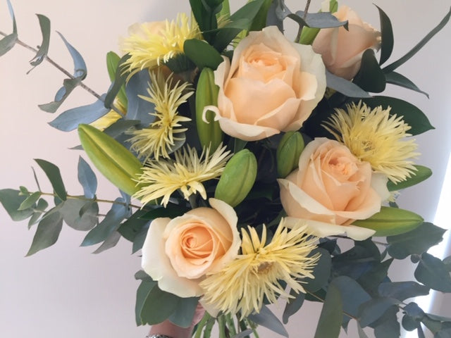Bright bouquet with lillium,roses,filler flower like chrysanthemum and in season foliage, gift wrapped to compliment flowers and delivered with a water bag for freshness.