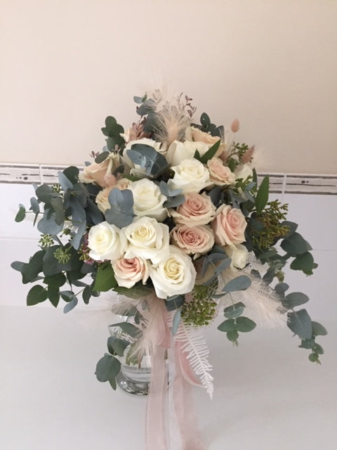 Beautiful pastel roses with light and airy foliage and filler in a hand tied bouquet gift wrapped in complimenting paper and a beautiful bow, delivered with a water bag for freshness. choice of 10 or 18 stems .