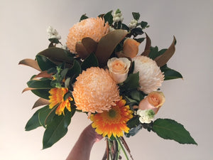 Bright bouquet with disbuds,roses in the medium size,gerberas,filler flowers and foliages of in season ingredients,gift wrapped and delivered with a water bag for freshness.