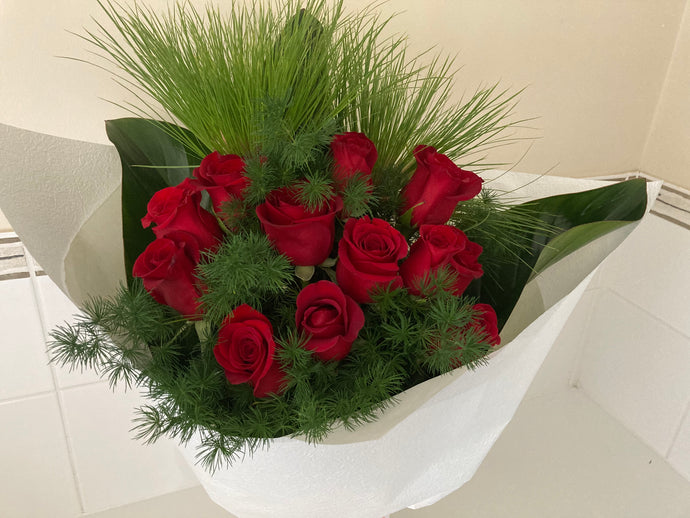 12 red roses in bouquet with foliage gift wrapped